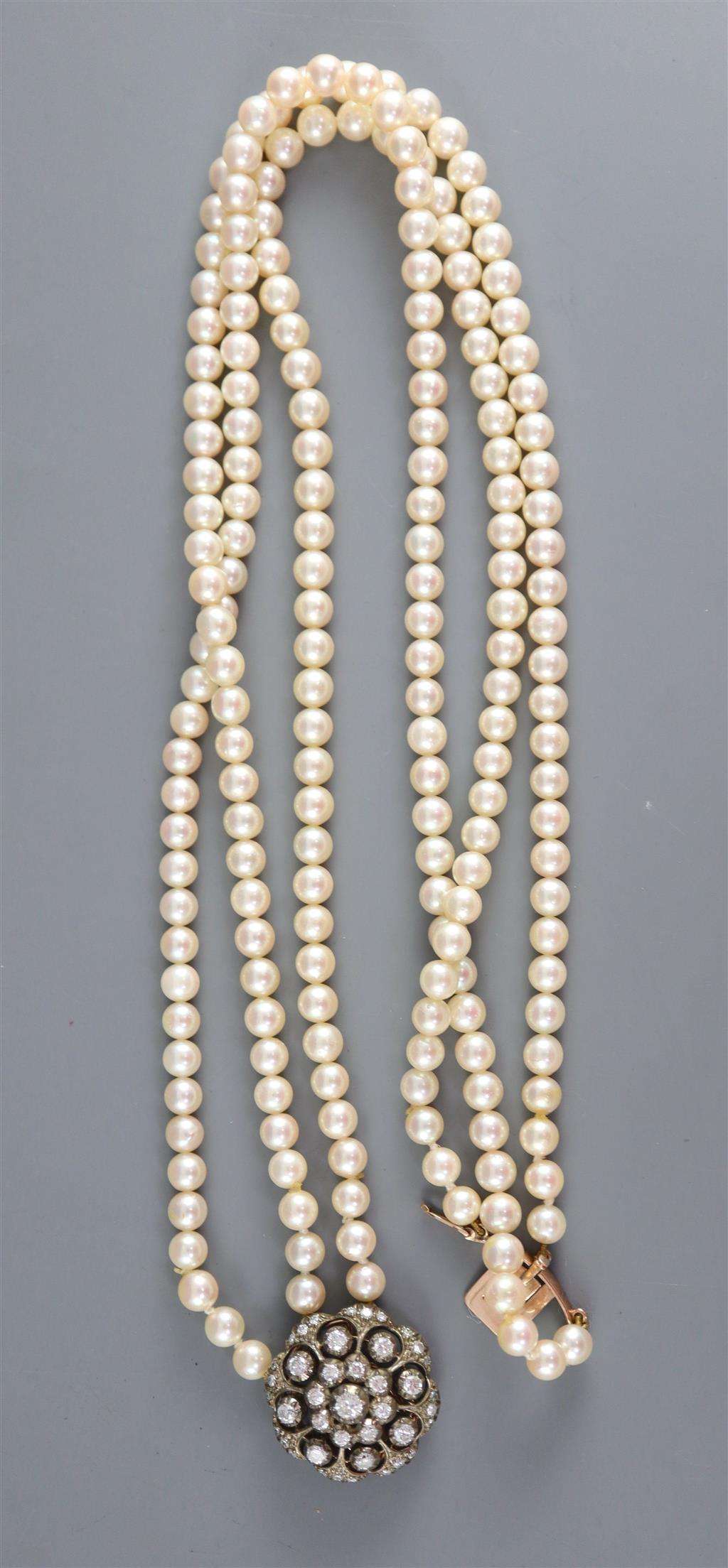 A modern triple row cultured pearl necklace with an earlier Victorian gold, silver and diamond cluster set clasp,